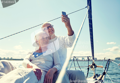 Image of senior couple taking selfie by smartphone on yacht