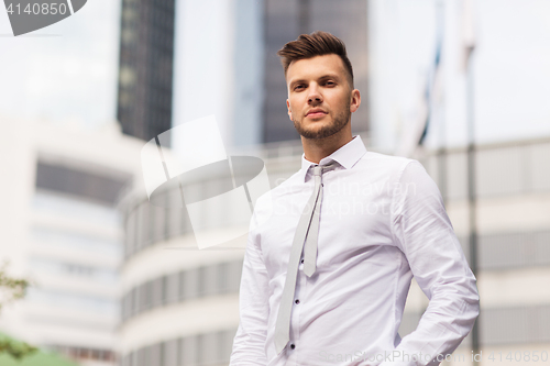 Image of young man in shirt and tie on city street