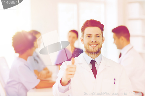 Image of happy doctor over group of medics at hospital