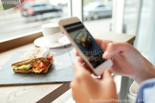 Image of hands with smartphone photographing food