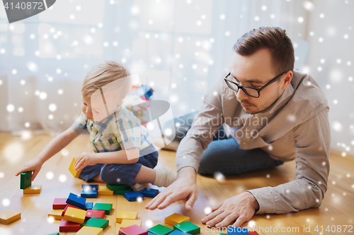 Image of father and son playing with toy blocks at home