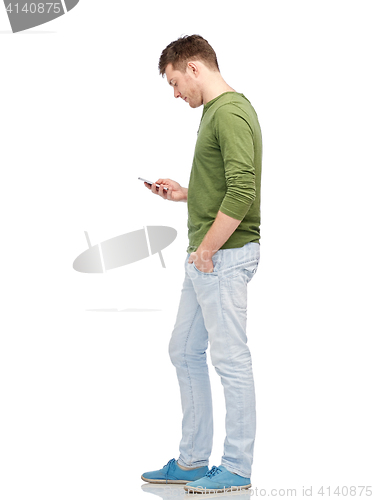Image of young man texting on smartphone over white