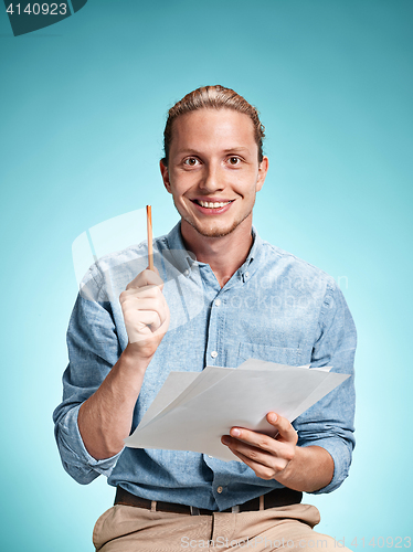 Image of Smart smiling student with great idea holding sheets of paper