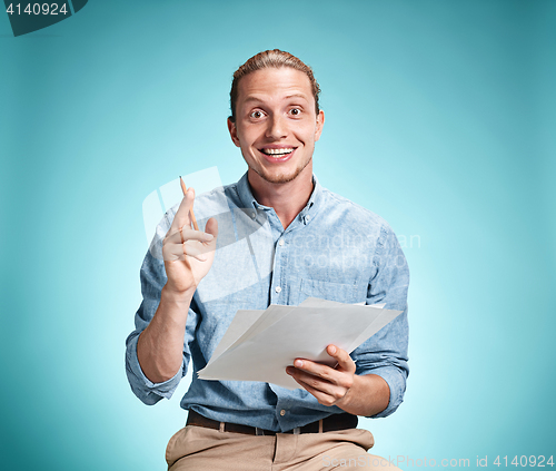 Image of Smart smiling student with great idea holding sheets of paper