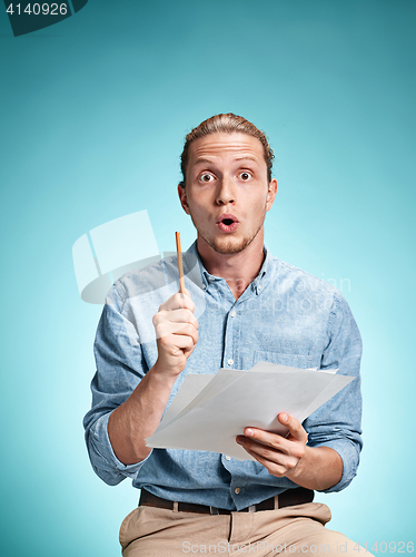 Image of Smart surprised student with great idea holding sheets of paper