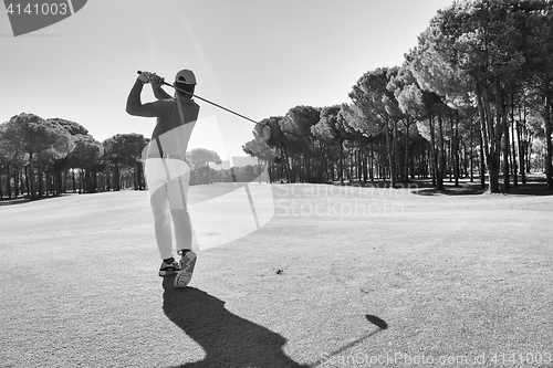 Image of golf player hitting shot with club