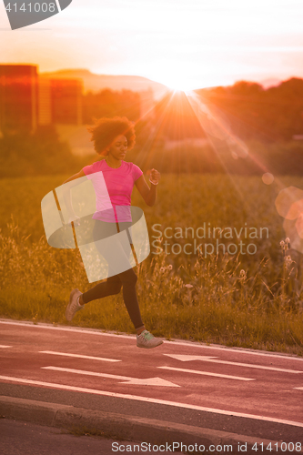 Image of a young African American woman jogging outdoors