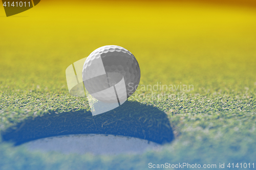 Image of golf ball on lip of cup