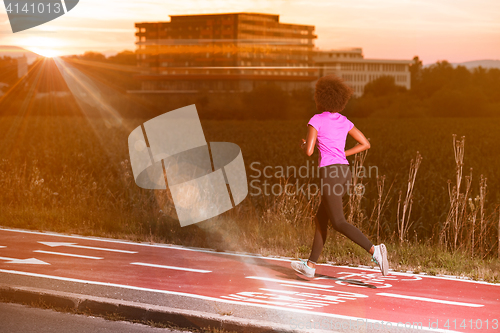 Image of a young African American woman jogging outdoors