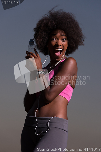 Image of african american woman jogging in nature