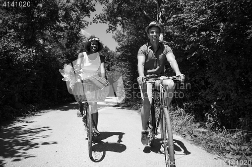 Image of Young multiethnic couple having a bike ride in nature