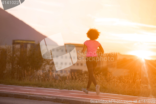 Image of a young African American woman jogging outdoors