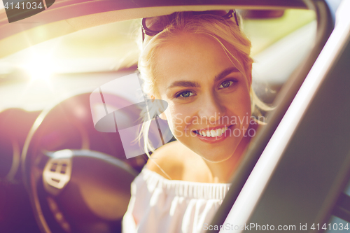 Image of happy teenage girl or young woman in car