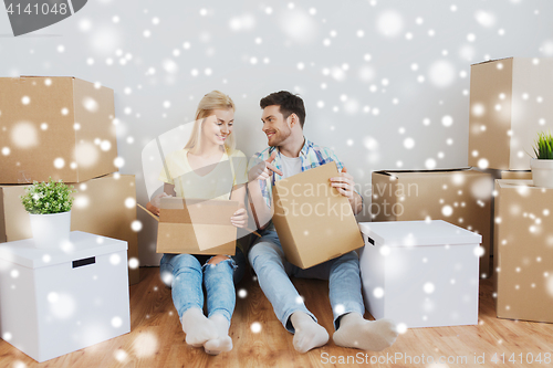 Image of smiling couple with big boxes moving to new home