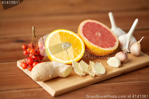 Image of citrus, ginger, garlic and rowanberry on wood