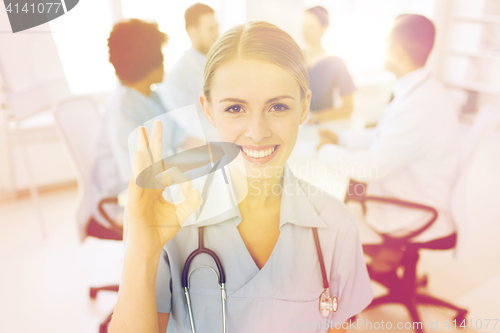 Image of happy doctor over group of medics at hospital