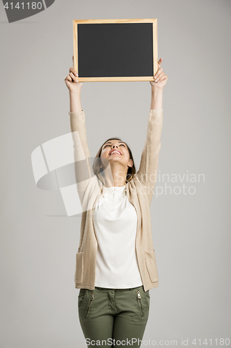 Image of Woman showing something on a chalkboard