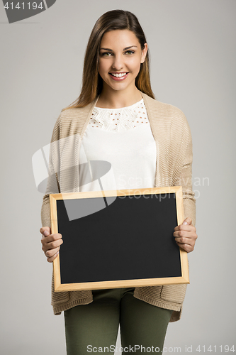 Image of Woman showing something on a chalkboard