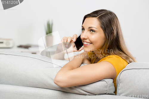 Image of Young woman talking at phone