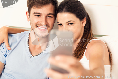 Image of Couple on bed making selfies