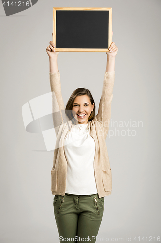 Image of Woman showing something on a chalkboard