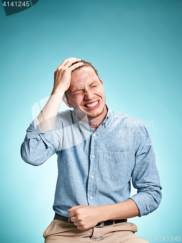 Image of The disappointed young man over blue background