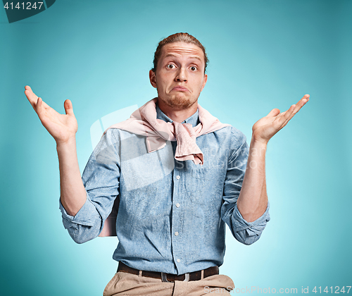 Image of The surprised young man over blue background