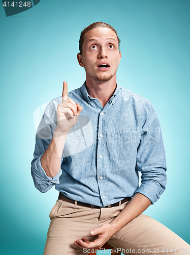 Image of The surprised young man over blue background