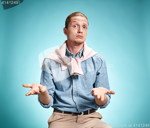 Image of The surprised young man over blue background