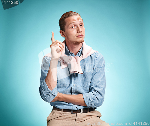 Image of The serious young man over blue background