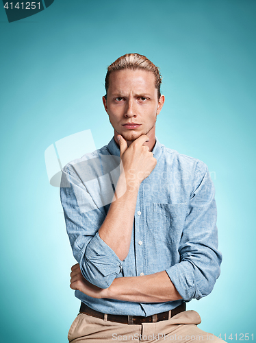 Image of The serious young man over blue background