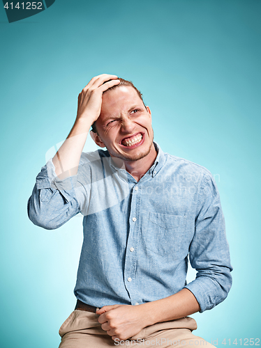 Image of The disappointed young man over blue background