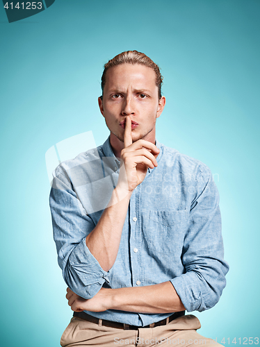 Image of The serious young man over blue background