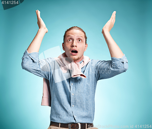 Image of The surprised young man over blue background