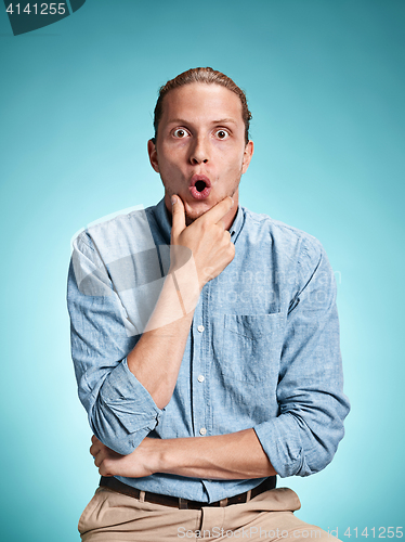 Image of The surprised young man over blue background