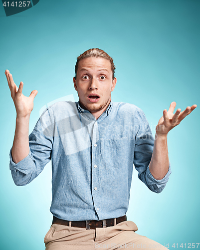 Image of The surprised young man over blue background