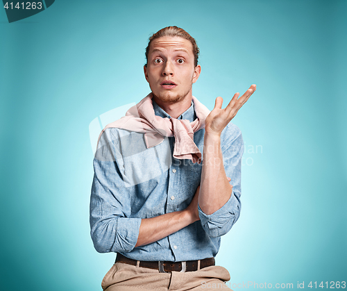 Image of The surprised young man over blue background