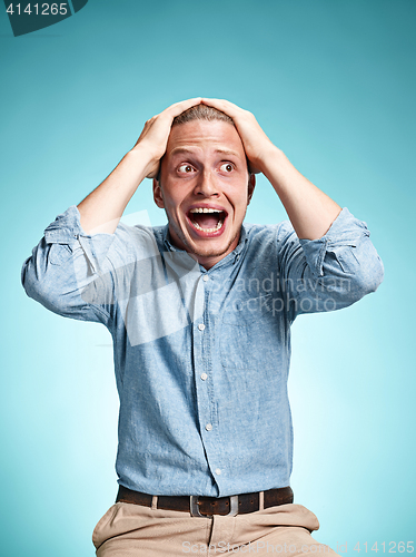 Image of The disappointed young man over blue background