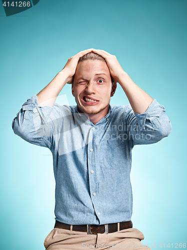 Image of The disappointed young man over blue background