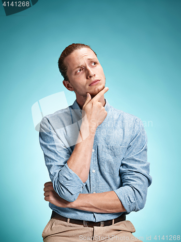 Image of The serious young man over blue background