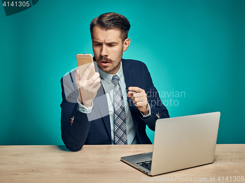 Image of Sad Young Man Working On Laptop At Desk