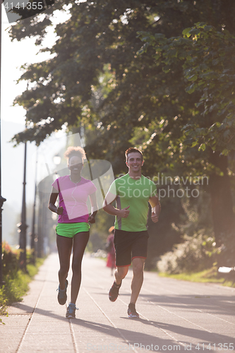 Image of young multiethnic couple jogging in the city