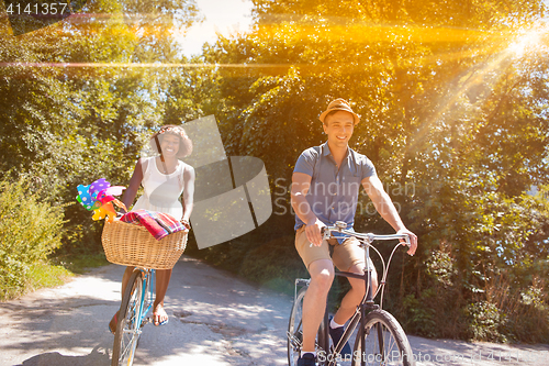 Image of Young multiethnic couple having a bike ride in nature