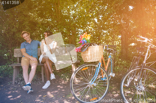 Image of Young multiethnic couple having a bike ride in nature