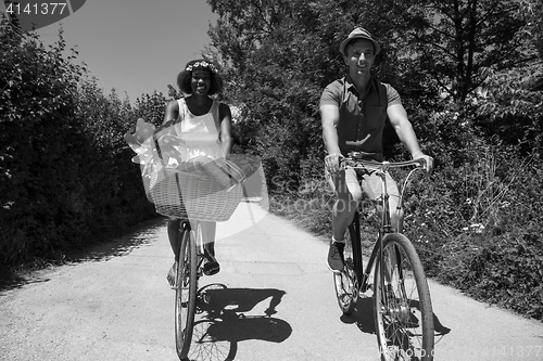 Image of Young multiethnic couple having a bike ride in nature