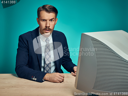 Image of Sad Young Man Working On computer At Desk