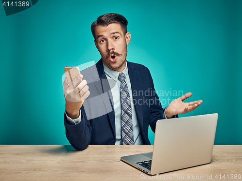 Image of Sad Young Man Working On Laptop At Desk