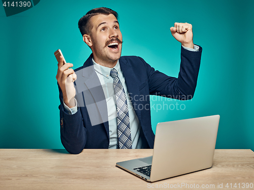 Image of Sad Young Man Working On Laptop At Desk