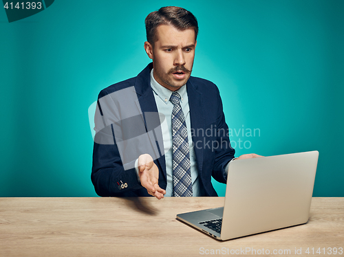 Image of Sad Young Man Working On Laptop At Desk