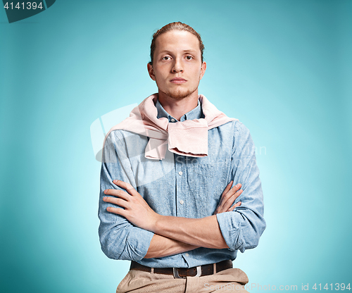 Image of The serious young man over blue background